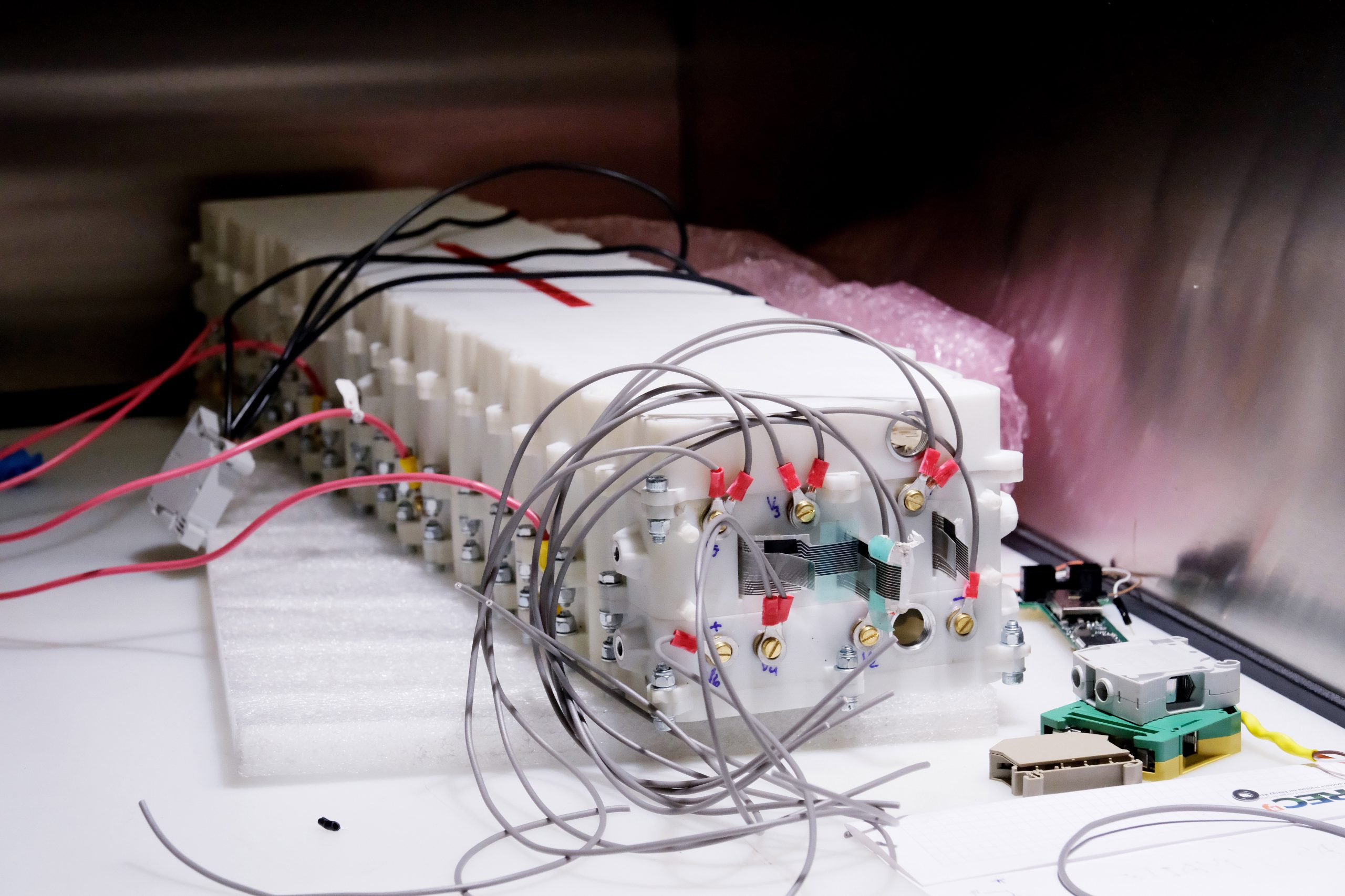 Laboratory equipment surrounded by cables, representing life cycle assessment tools and digital methodologies for evaluating the environmental and social impact of energy technologies