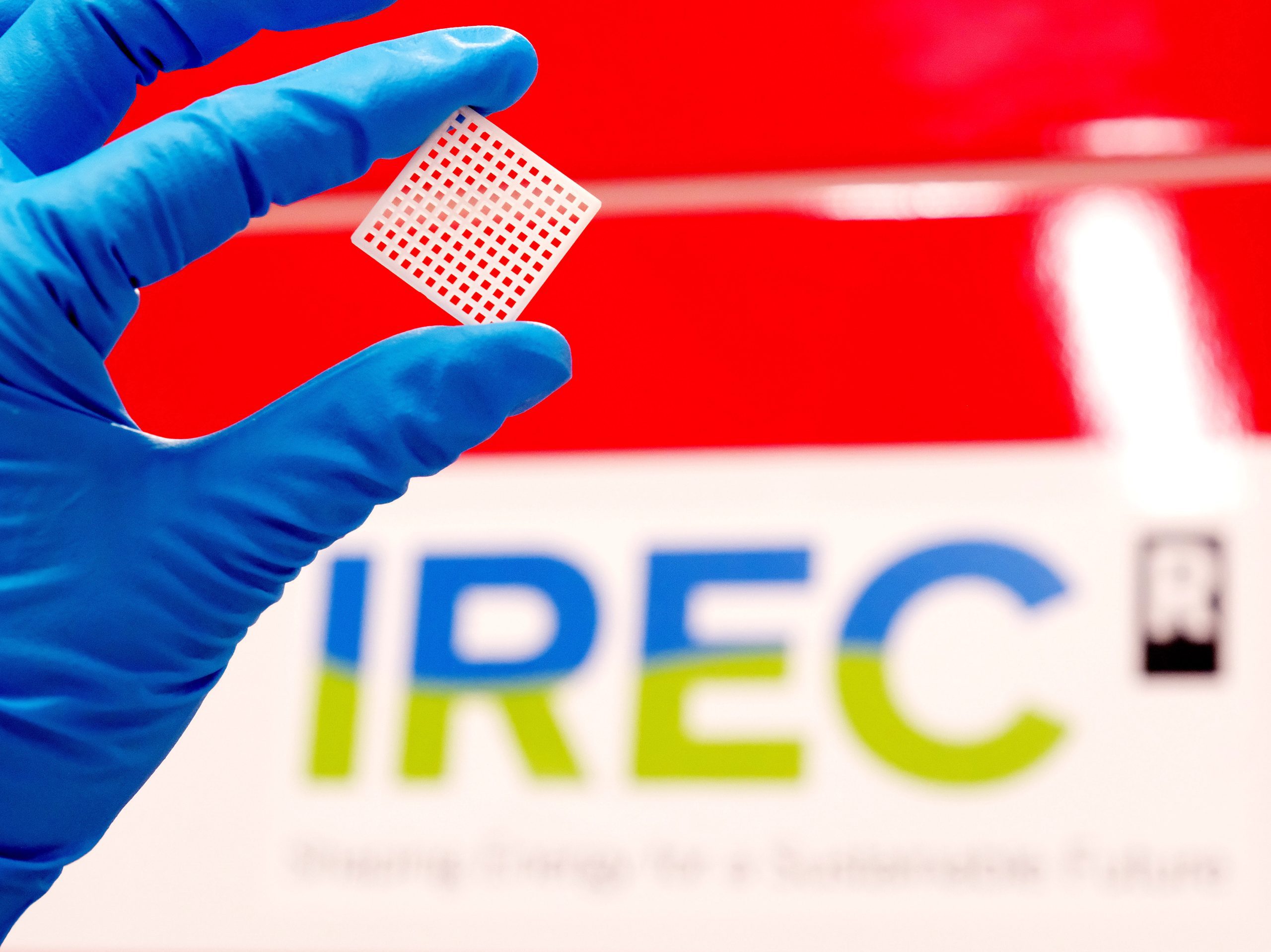 Close-up of a small grid-like ceramic component used in advanced battery systems, featuring a structured lattice design for ion conduction and solid-state energy storage applications.