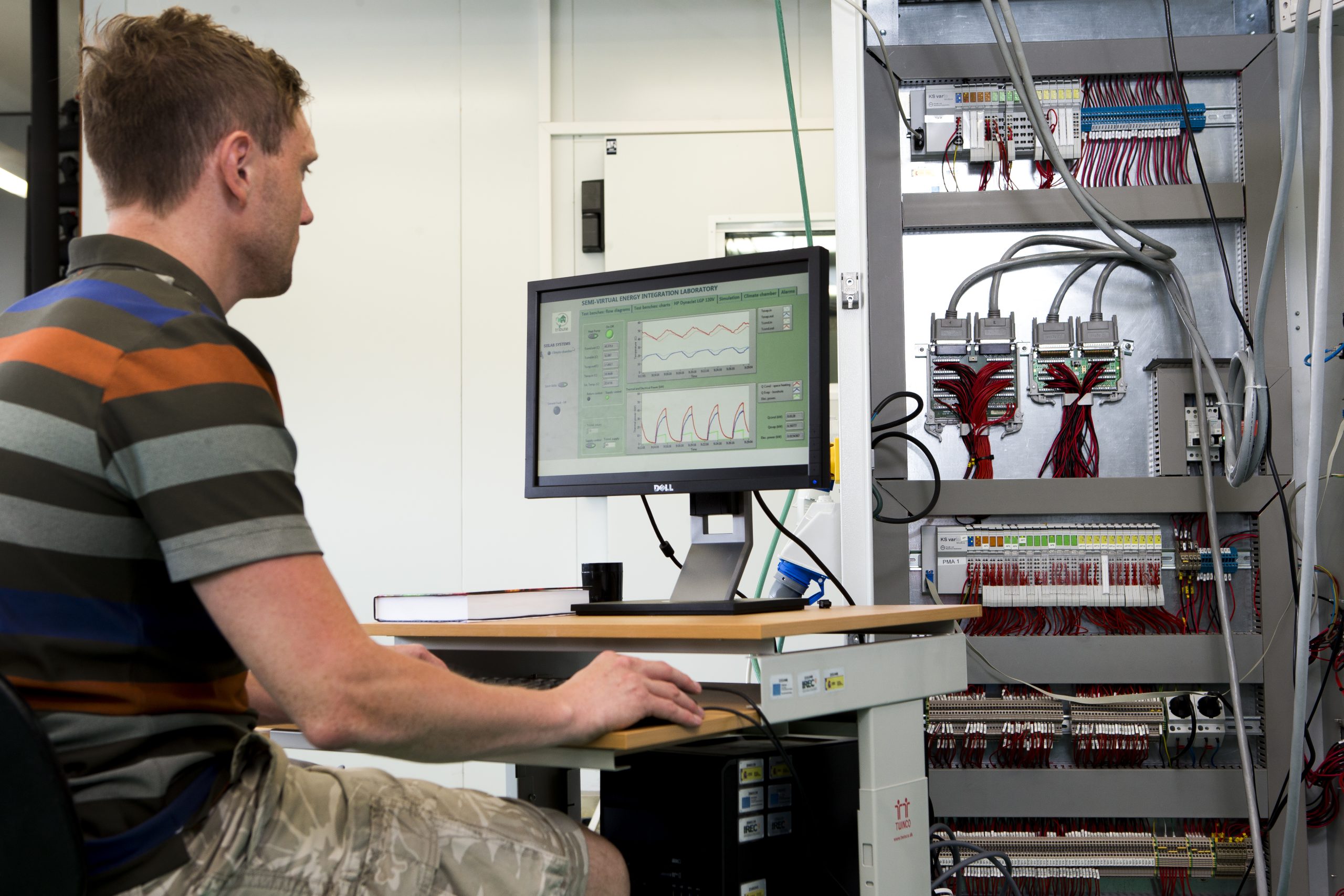Researcher analyzing energy system data on a computer with graphical visualizations for decarbonisation modelling, energy transition planning and policy analysis.