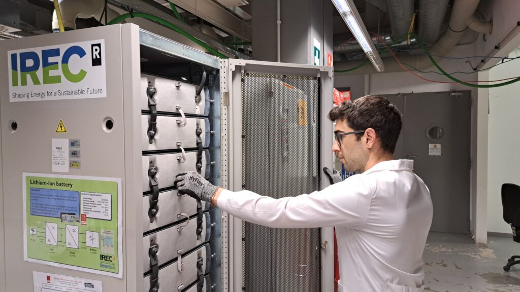 Person handling a module inside an open lithium-ion battery storage cabinet